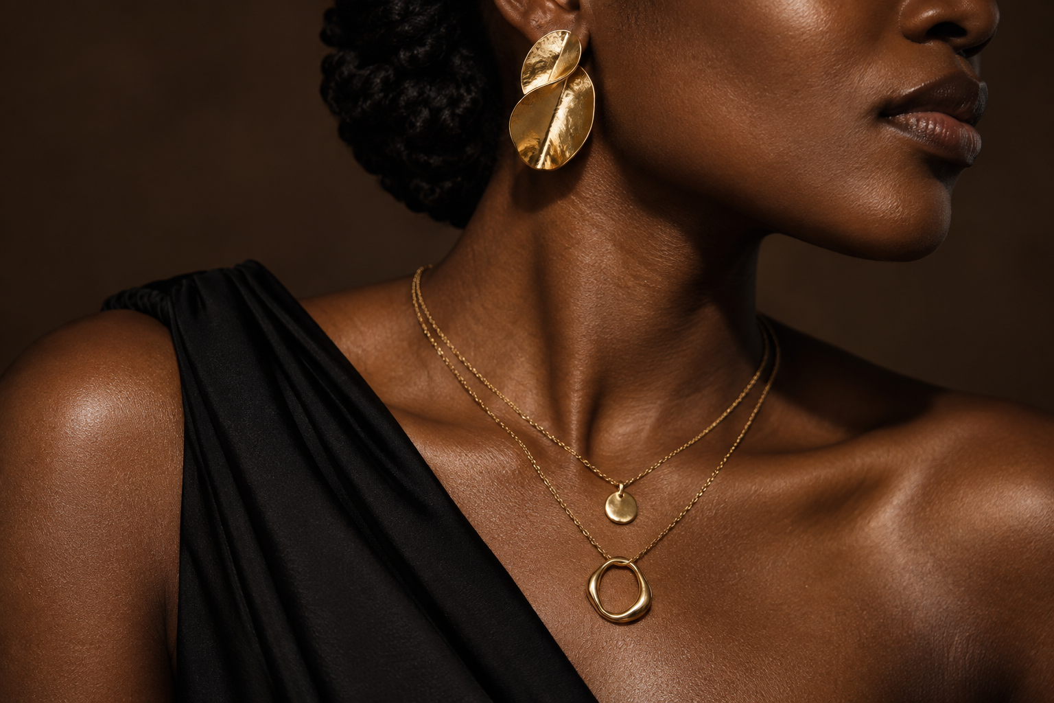 Portrait de campagne : bijoux dorés portés avec une tenue noire — visuel illustratif